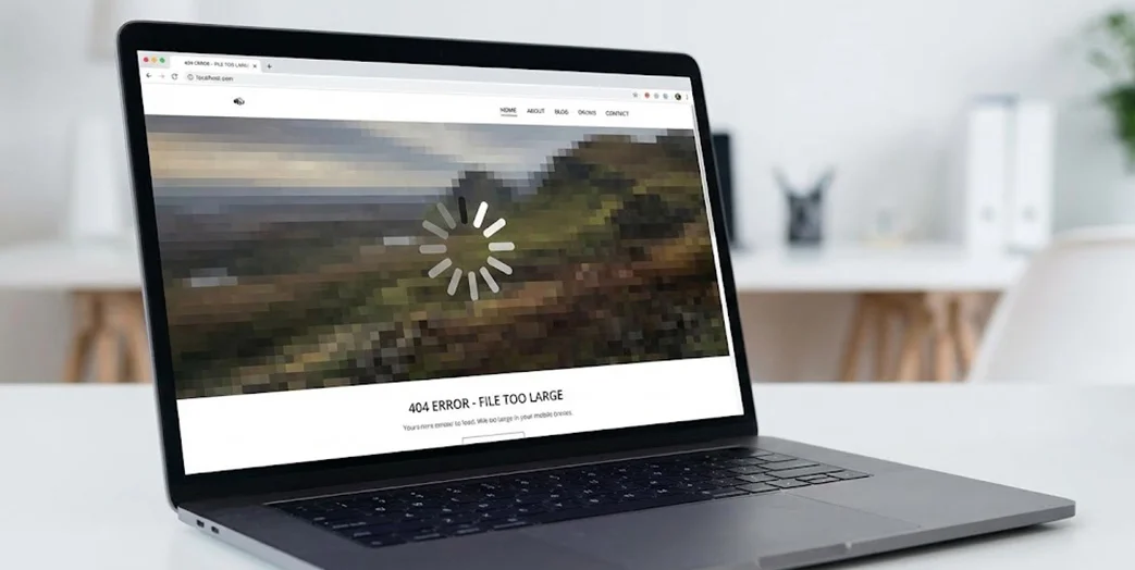 Ordinateur portable affichant une page web qui charge très lentement avec une image pixelisée et une icône de chargement.